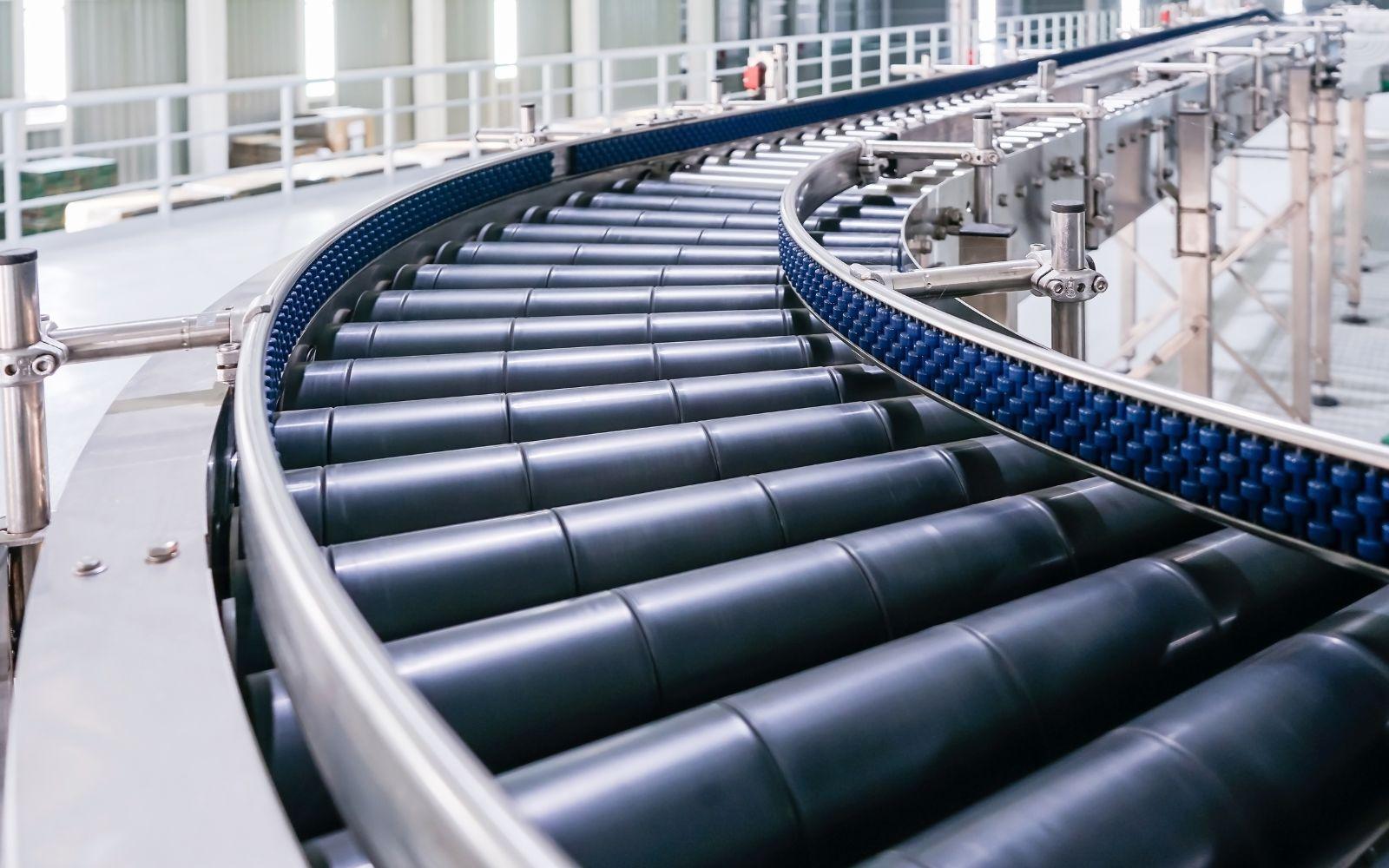 Curved gravity roller conveyor bend with dark rollers and blue side frames