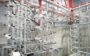 Multi tier overhead spiral conveyor system carrying product on tracks through a plant
